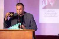 С.С. Антипов в ходе выступления  демонстрирует медаль "Александр Грин" авторства Э.В. Хандюкова. 22.08.2025г